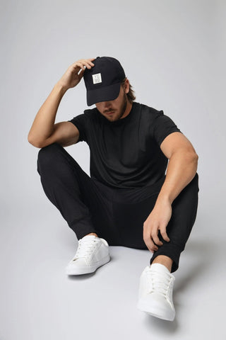 The Avery Cap styled with casual attire, representing Yebo Clothing's commitment to eco-friendly gym clothes. This cap combines minimalist loungewear aesthetics with performance features like moisture-wicking fabric for effortless comfort.